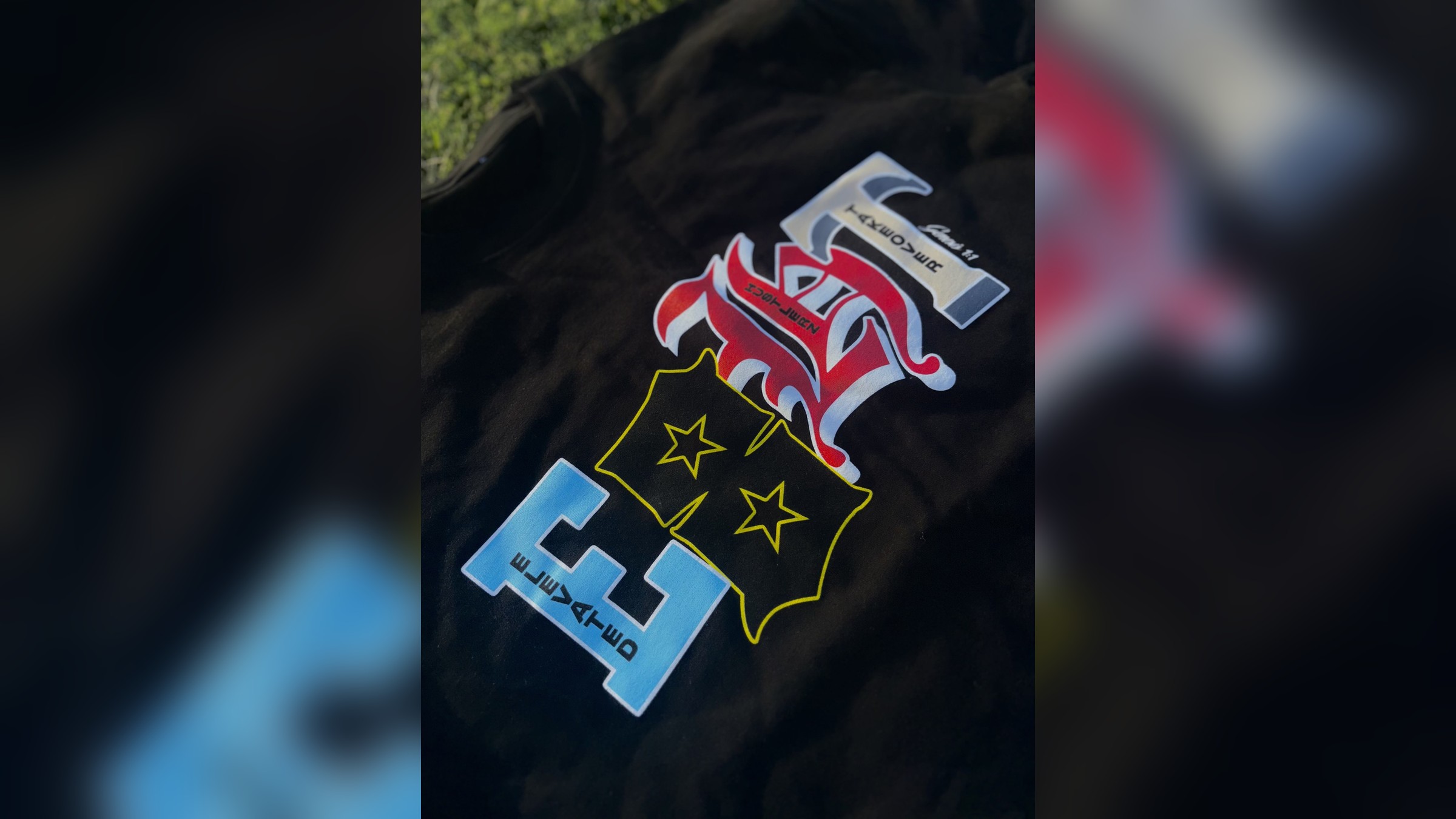 E8HT black tee laid out on grass with the College Dropout graphic print centered